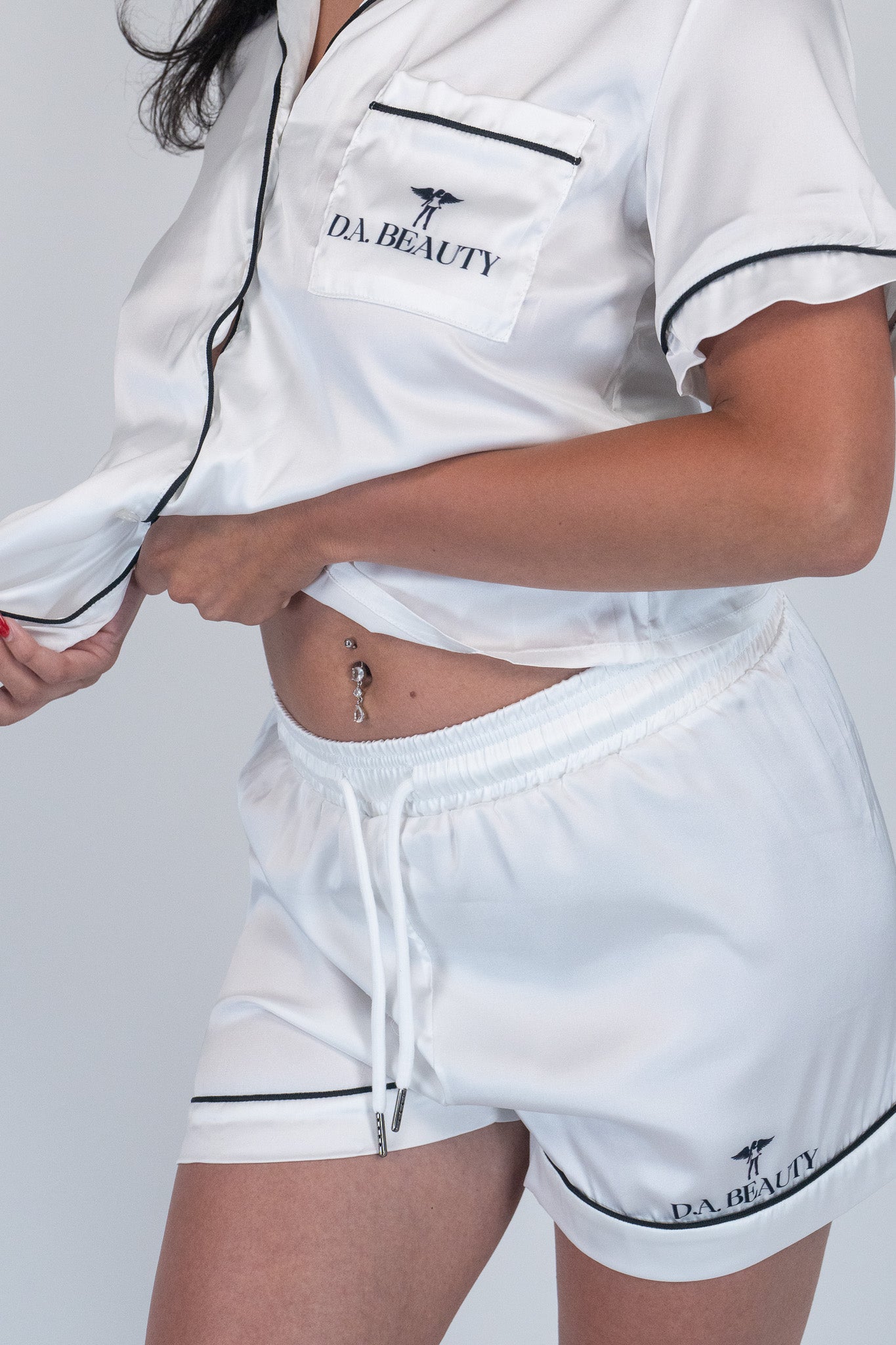 White outfit with 'DA BEAUTY' branding on a plain background