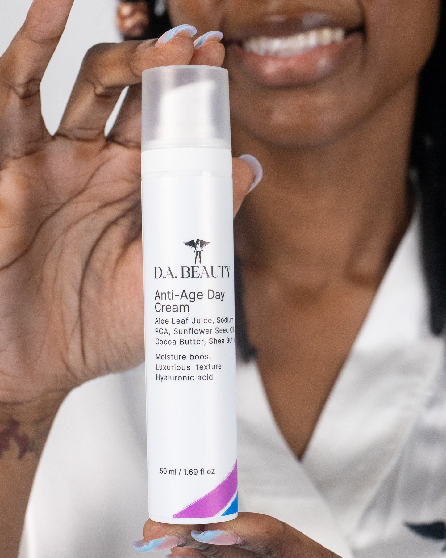 Person holding a bottle of D.A. Beauty Anti-Age Day Cream with a blurred background