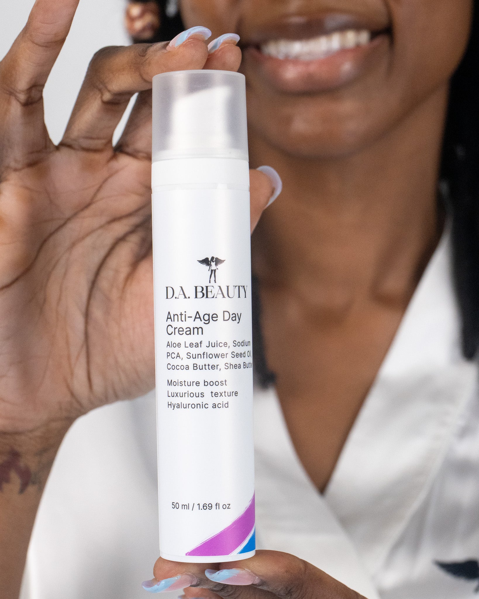 Person holding a bottle of D.A. Beauty Anti-Age Day Cream with a blurred background