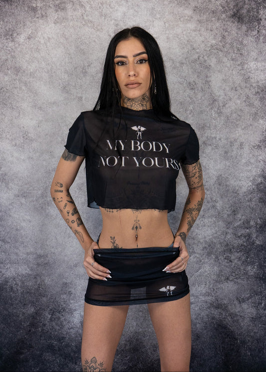 Person wearing a black crop top with 'My Body, Not Yours' text against a textured gray background