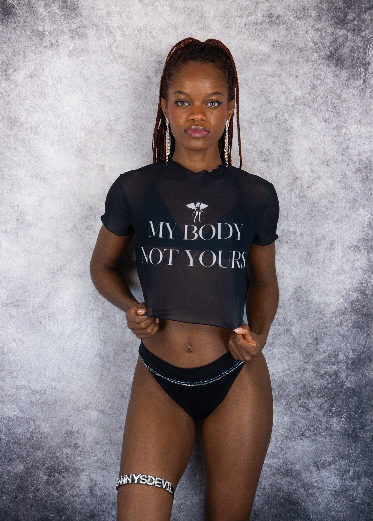 Woman wearing a black t-shirt with 'MY BODY NOT YOURS' text against a gray textured background.